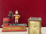 une petite horloge posée à côté d'une petite figurine représentant un pompier