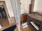 a person standing in a room with a bed and a floor lamp