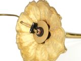 a close up of a gold flower with a button on it