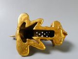 a gold brooch that has been made to look like an airplane