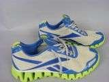 une paire de chaussures de course blanches et bleues à semelles vertes