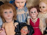 a lot of dolls that are sitting together on a couch