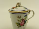 a small cup with a lid on a white table