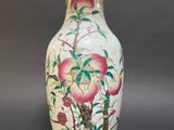 a vase with a painting on it sitting on a table