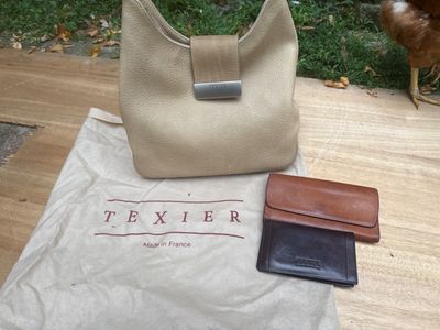 un sac, un portefeuille et un poulet posés sur une table