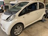 a small white car that is parked in a garage