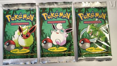 three packs of pokemon trading cards on a white surface