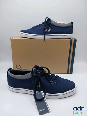 un gros plan sur une paire de chaussures bleues posées sur une boîte