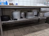 many pots and pans sitting on a shelf in a kitchen