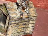 statue d'un chien assis dans une caisse en bois posée sur une table