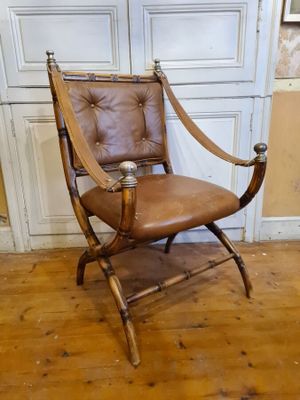 a brown leather chair sitting in front of a white door