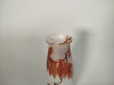 a glass vase with a brown and white design on it
