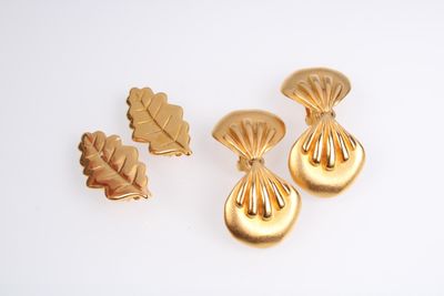 trois boucles d'oreilles dorées et une broche en forme de feuille