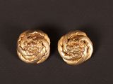 pair of gold tone flower earrings on a black background
