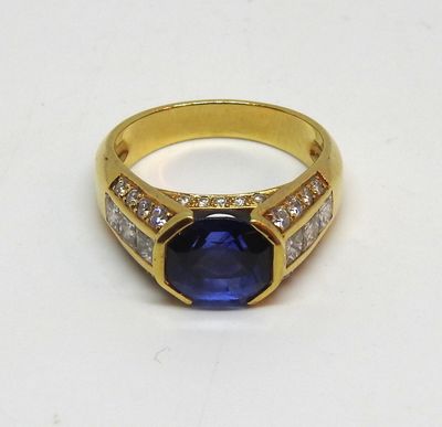une image représentant une bague en or sertie d'une pierre bleue entourée de diamants