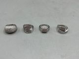 trois bagues ornées de diamants, posées sur une surface blanche