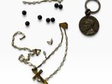 une image représentant un collier, une boucle d'oreille et une pièce de monnaie posés sur une surface blanche