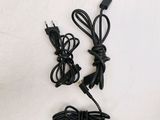 two black power cords and a charger on a white surface