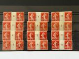 Plusieurs timbres de tailles et de couleurs différentes sont exposés dans une vitrine.