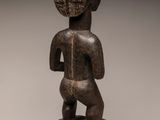 a wooden statue of a man standing on top of a wooden base