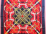 une écharpe carrée rouge et bleue ornée d'un motif doré et noir