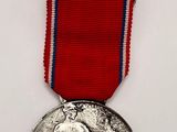 the medal has a red ribbon around it and a blue ribbon around it