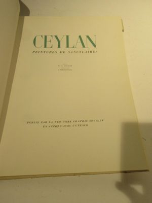 un livre posé sur une étagère à côté d'une horloge
