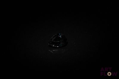 un gros plan d'une bague dans l'obscurité, sur fond noir