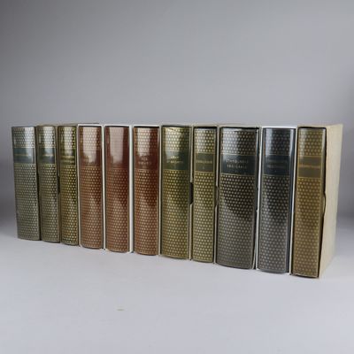 several books are lined up in a row on a white surface
