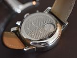 a close up of a watch on a brown surface
