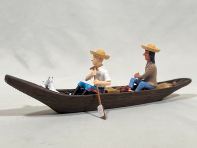 two figurines of two people in a boat on a white background