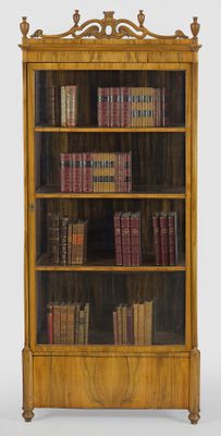a bookcase with many books on it in a room