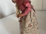 a figurine of an old woman with a cane