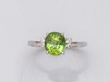 une bague en tourmaline verte et diamants sur fond blanc