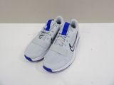 une paire de baskets blanches et bleues posées sur une surface blanche