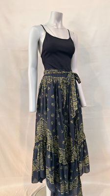 a mannequin wearing a dress with a black top and gold print skirt
