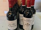 trois bouteilles de vin rouge posées sur un plan de travail, à côté d'un carton