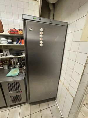 une photo d'une cuisine avec un réfrigérateur dans un coin