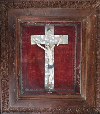 peinture représentant un crucifix dans un cadre en bois sur fond rouge