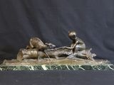 bronze statue of a boy and a dog on a marble base