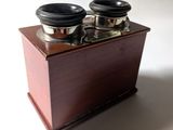 une petite boîte en bois munie de deux boutons métalliques