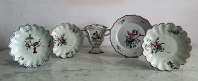 five plates and a vase sitting on a table