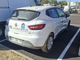 a white car parked in a parking lot next to a white truck