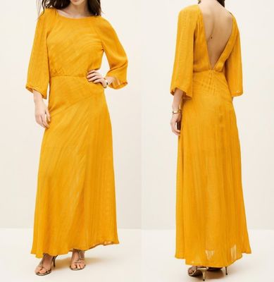 une femme vêtue d'une robe jaune dos nu et aux épaules dénudées