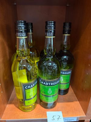 Plusieurs bouteilles d'alcool sont posées sur une étagère dans un magasin.