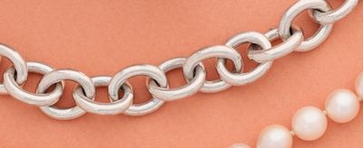 un gros plan sur un collier et deux perles posés sur une table
