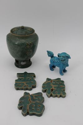 un petit vase vert et une petite figurine de chien bleue