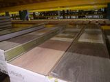 plusieurs piles de différents types de bois dans un entrepôt