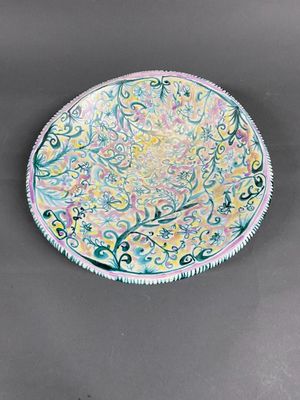 painting of a plate with a floral design on it on a gray surface