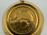 a close up of a coin in a gold pendant on a white surface